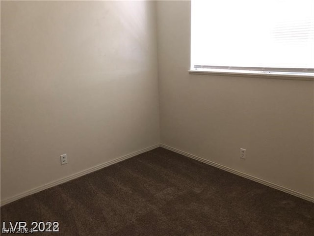 empty room with dark colored carpet