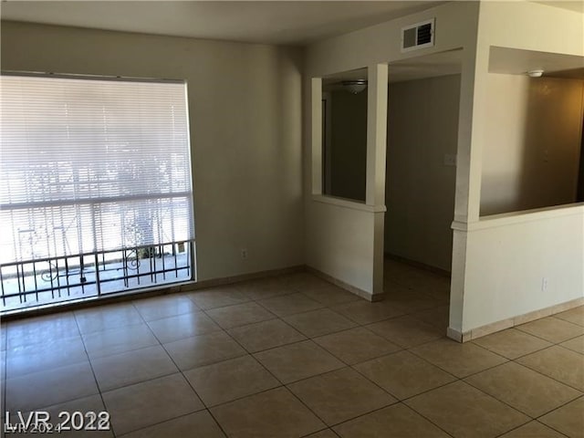 tiled empty room featuring ceiling fan