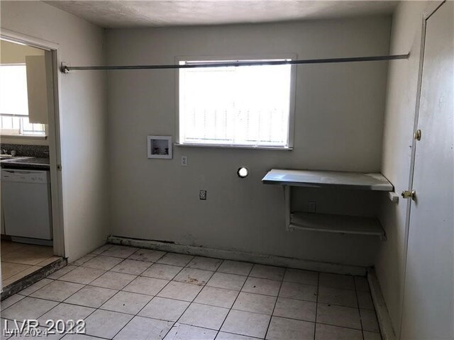 washroom with hookup for a washing machine and light tile floors