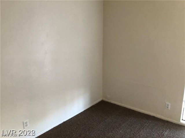 unfurnished room with dark colored carpet