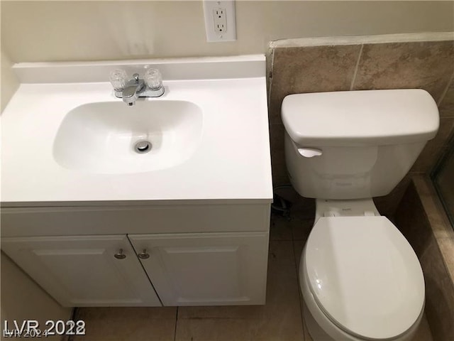 bathroom featuring toilet, tile floors, and vanity