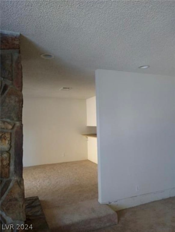 interior space with a stone fireplace and a textured ceiling