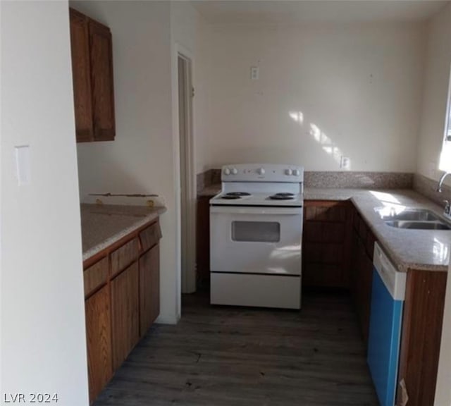 kitchen featuring white appliances, dark wood-type flooring, and sink