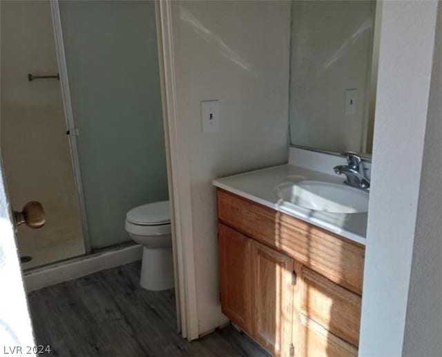 bathroom with walk in shower, toilet, hardwood / wood-style floors, and vanity