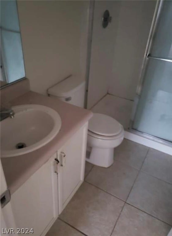 bathroom with walk in shower, tile floors, large vanity, and toilet