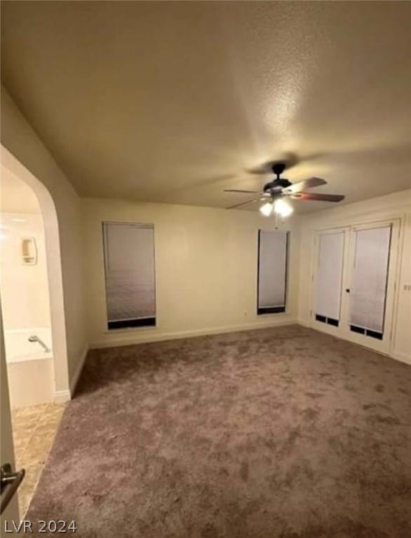 spare room with ceiling fan and light colored carpet