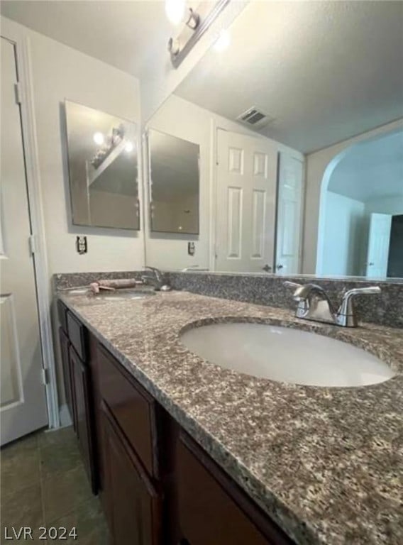 bathroom with double sink vanity and tile floors