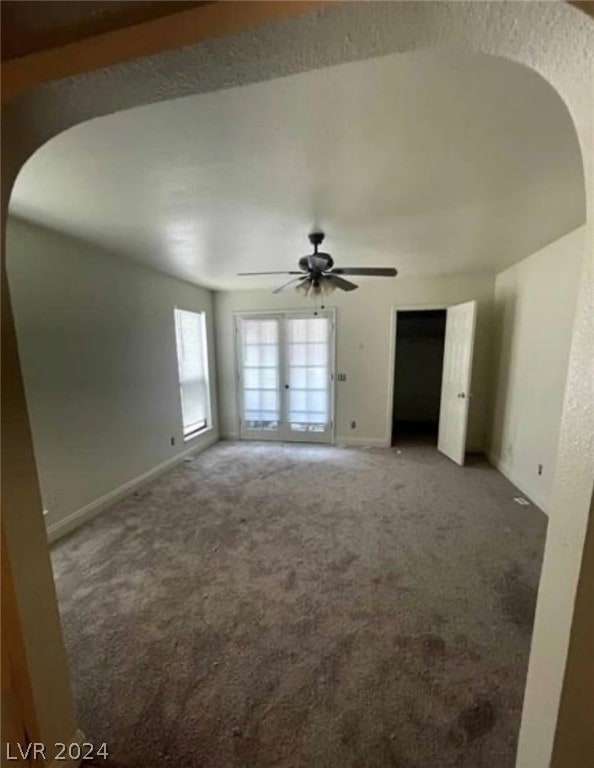 carpeted spare room with french doors and ceiling fan