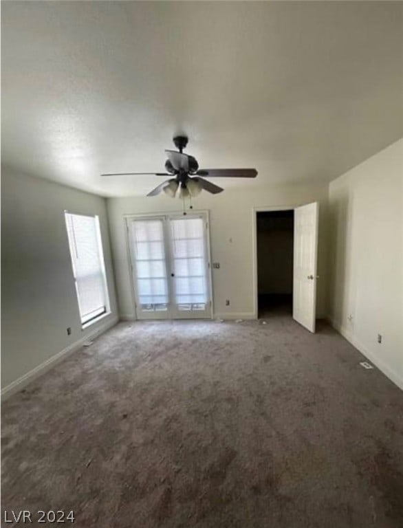 carpeted spare room with french doors and ceiling fan