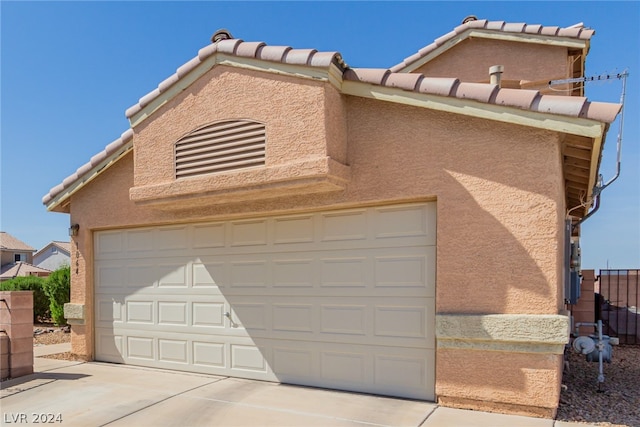 view of front of house with driveway, fence, and stucco siding