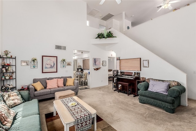 carpeted living area with a ceiling fan, visible vents, and a high ceiling