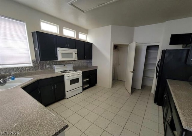 kitchen with backsplash, white appliances, sink, and light tile floors