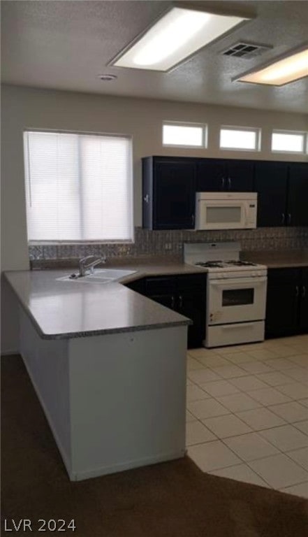 kitchen with light tile flooring, backsplash, white appliances, and sink