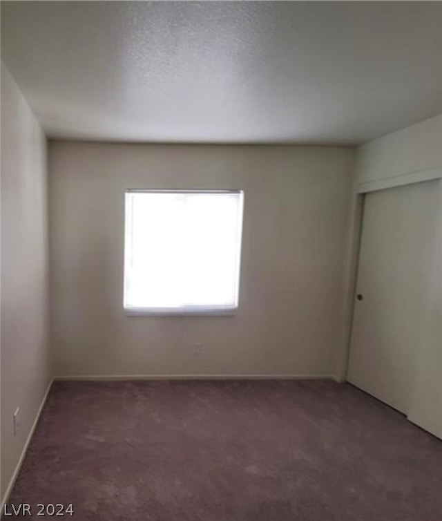 carpeted empty room with a textured ceiling