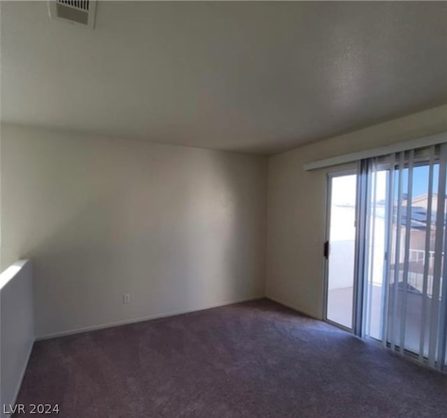 spare room with dark colored carpet