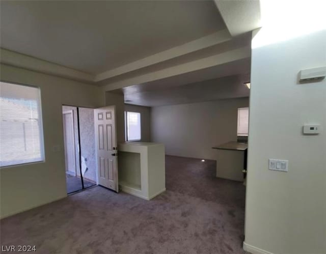 unfurnished bedroom with a tray ceiling, a closet, and dark colored carpet