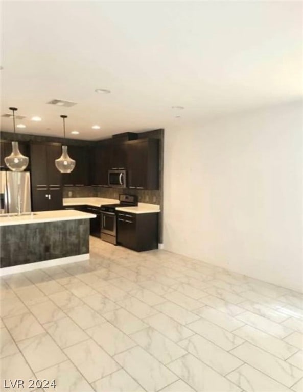 kitchen featuring hanging light fixtures, light tile floors, and appliances with stainless steel finishes