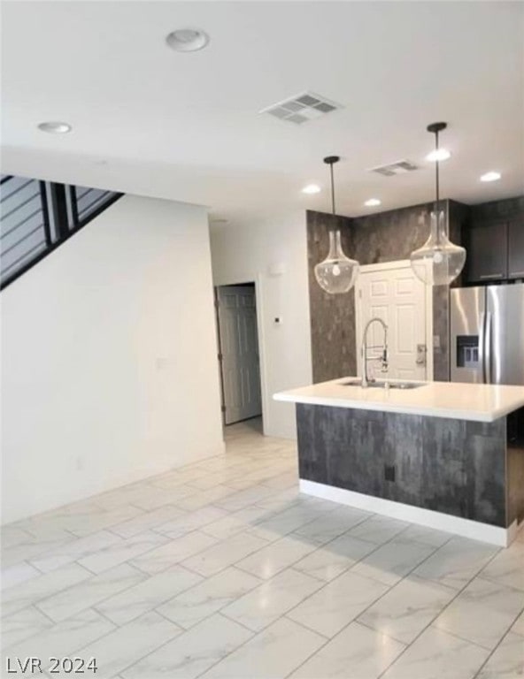 kitchen featuring pendant lighting, sink, stainless steel refrigerator with ice dispenser, and light tile floors