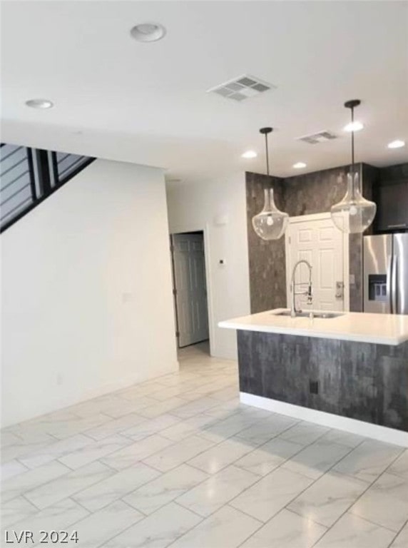 kitchen with hanging light fixtures, stainless steel refrigerator with ice dispenser, light tile flooring, and sink