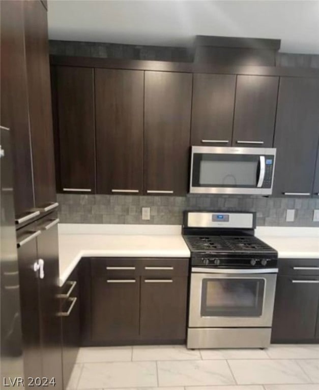 kitchen with appliances with stainless steel finishes, tasteful backsplash, dark brown cabinetry, and light tile floors