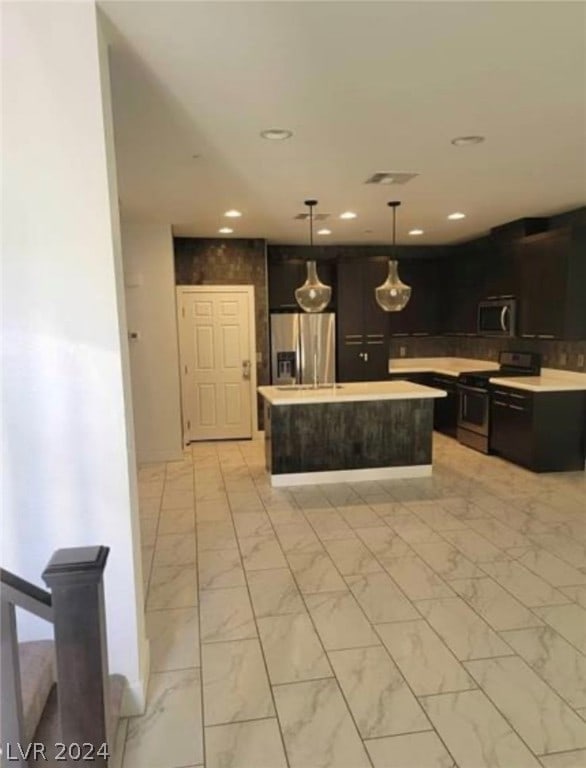 kitchen with light tile flooring, pendant lighting, stainless steel appliances, and a center island