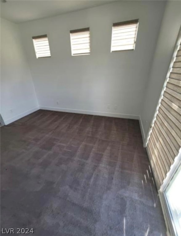 empty room with dark colored carpet