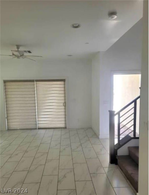 tiled spare room with ceiling fan