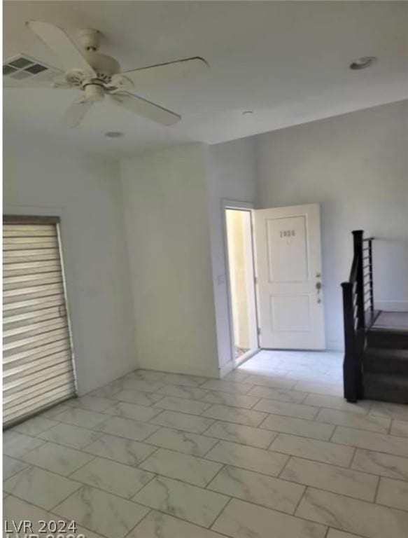 tiled spare room with ceiling fan