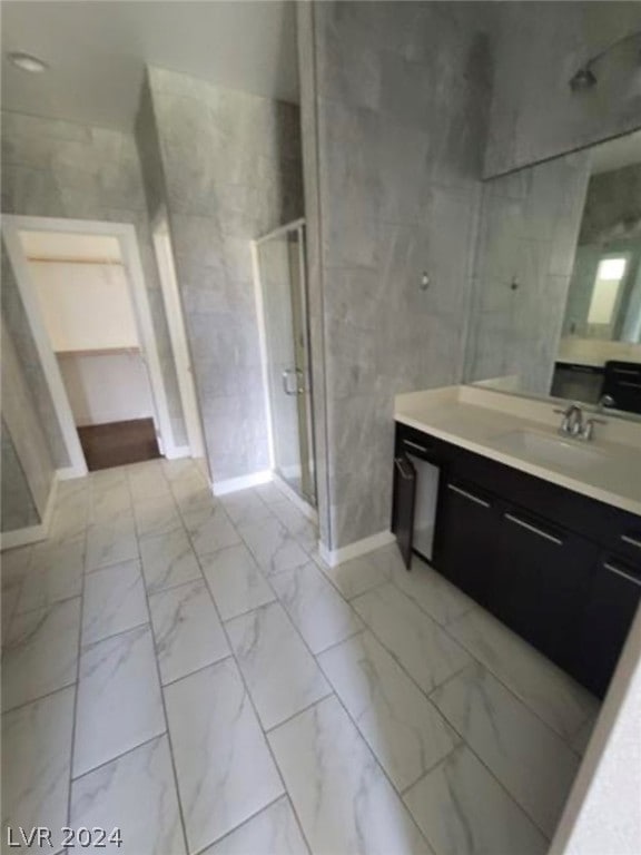 bathroom with tile floors, vanity, and an enclosed shower