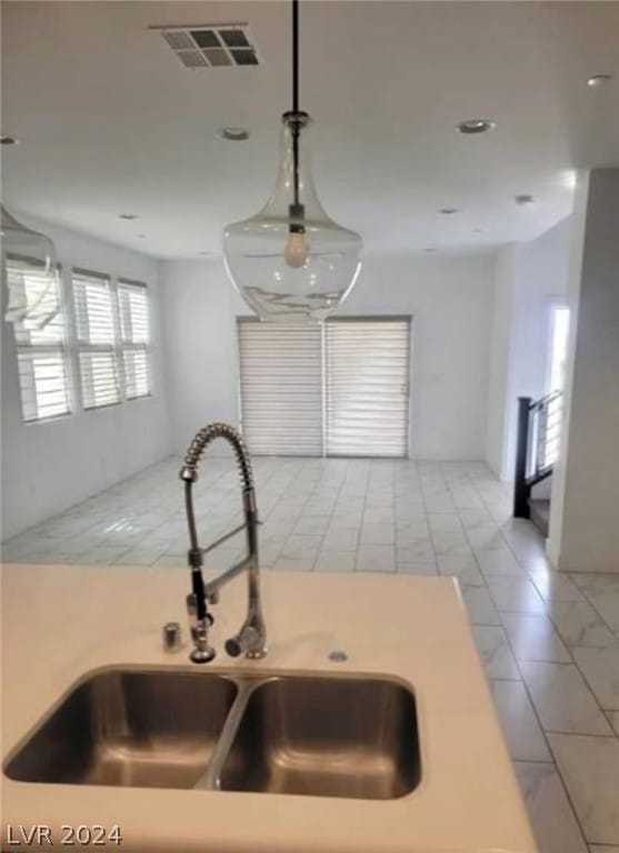 kitchen featuring hanging light fixtures, light tile flooring, and sink