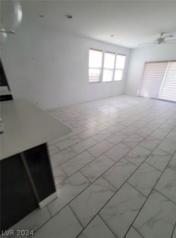 empty room featuring ceiling fan and light tile floors