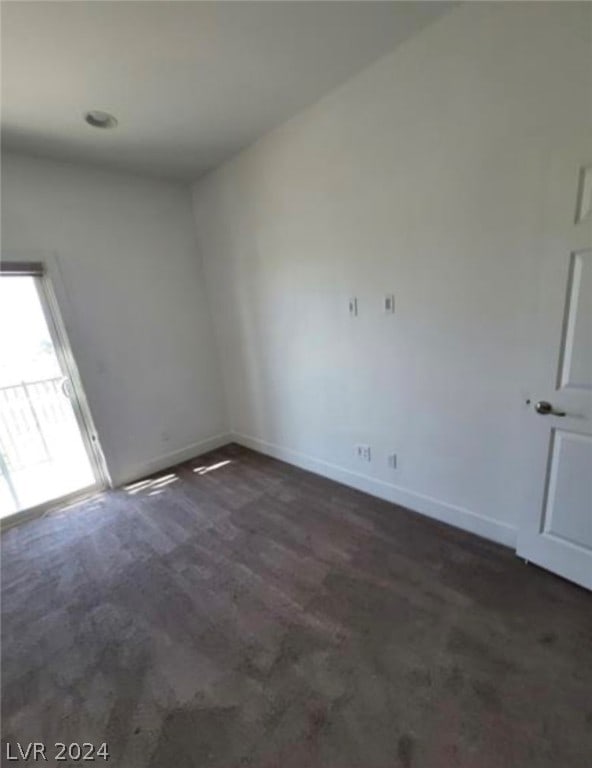 spare room with dark colored carpet