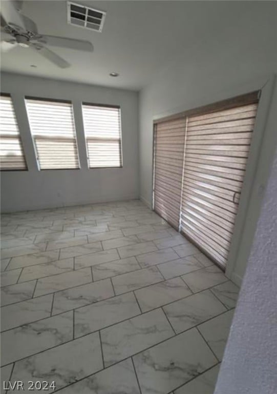 tiled empty room with ceiling fan