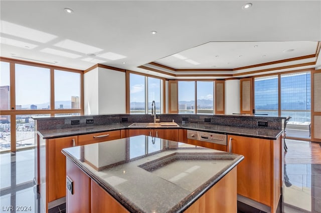 kitchen with a spacious island, stainless steel dishwasher, crown molding, and dark stone countertops