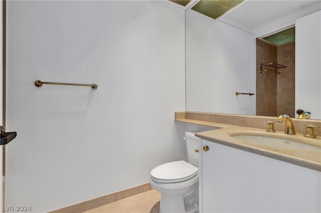 bathroom featuring toilet, vanity, and tile patterned flooring