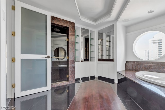 bathroom with a tray ceiling and tile patterned flooring