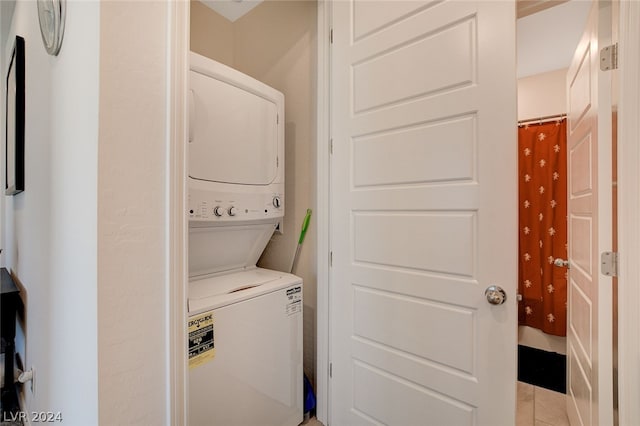 laundry area featuring light tile floors and stacked washer and clothes dryer