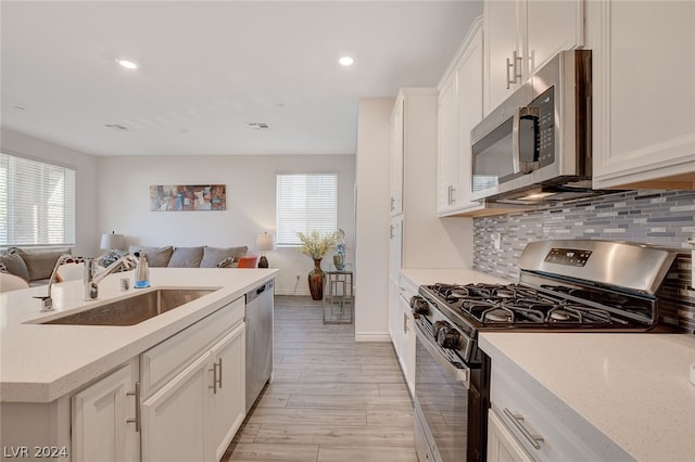 kitchen with backsplash, plenty of natural light, appliances with stainless steel finishes, and sink