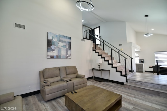 living room with beam ceiling, high vaulted ceiling, and wood-type flooring