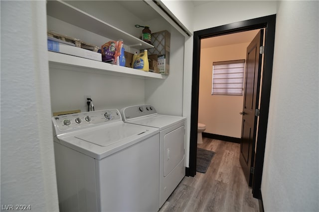 clothes washing area with independent washer and dryer and light wood-type flooring