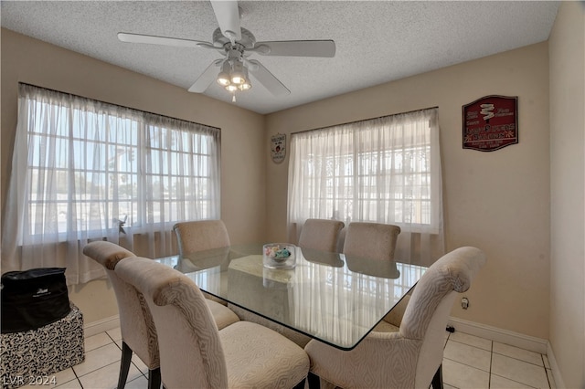 tiled dining room featuring a healthy amount of sunlight, a textured ceiling, and ceiling fan