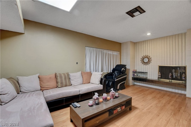 living room with a textured ceiling and light wood-type flooring