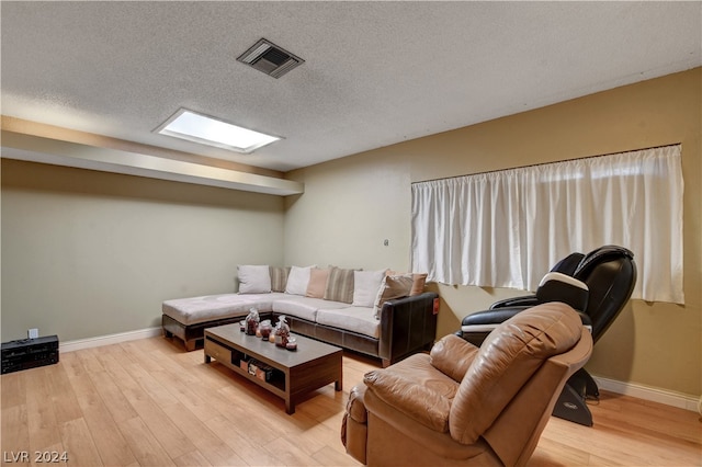 living room with light wood-type flooring and a textured ceiling