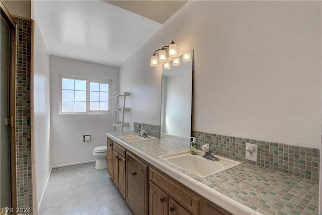 bathroom with backsplash, double vanity, tile flooring, and toilet