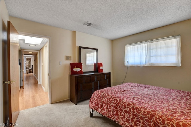 carpeted bedroom featuring a textured ceiling