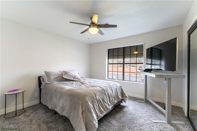 carpeted bedroom featuring ceiling fan and a textured ceiling