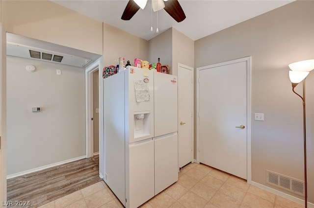 kitchen featuring light tile flooring, white fridge with ice dispenser, and ceiling fan