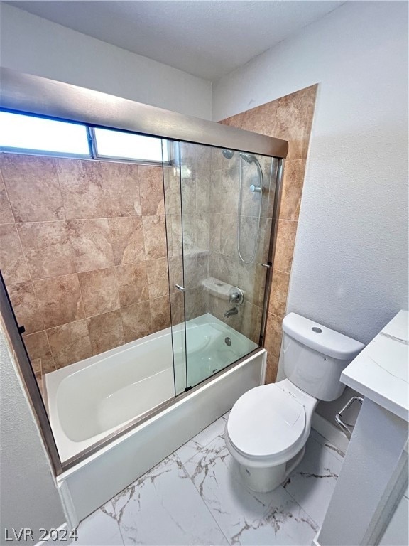 bathroom featuring tile flooring, toilet, and bath / shower combo with glass door