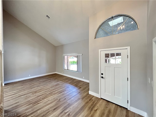 entryway with high vaulted ceiling and light wood-type flooring