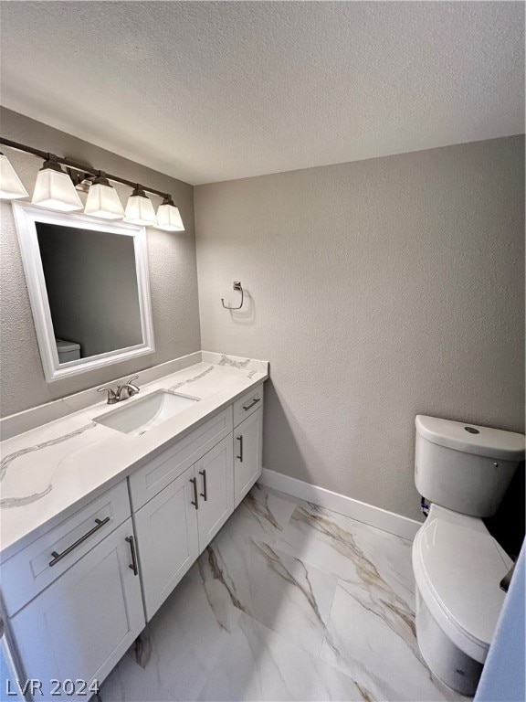 bathroom with toilet, tile flooring, vanity, and a textured ceiling